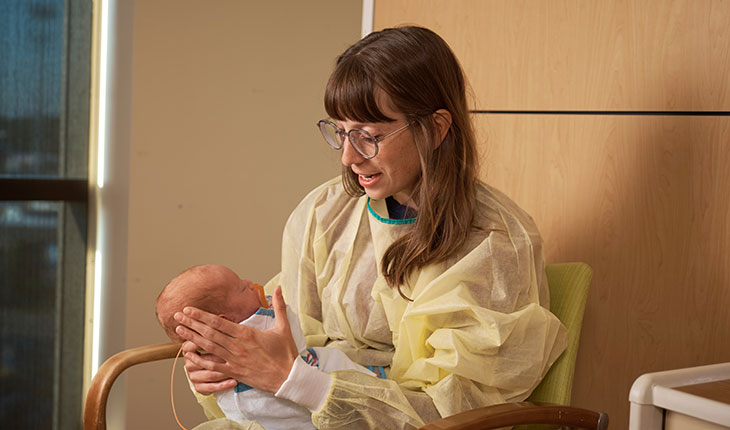 A music therapists sings to a baby in the neonatal intensive care unit.