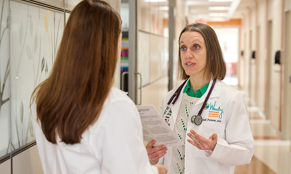 Lisal J. Folsom, M.D., is shown discussing Tzield with a colleague.