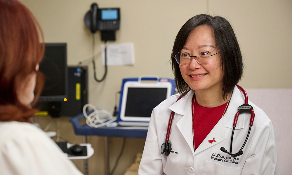 Li Zhou, M.D., Ph.D., chats with a patient about postpartum cardiovascular disease.