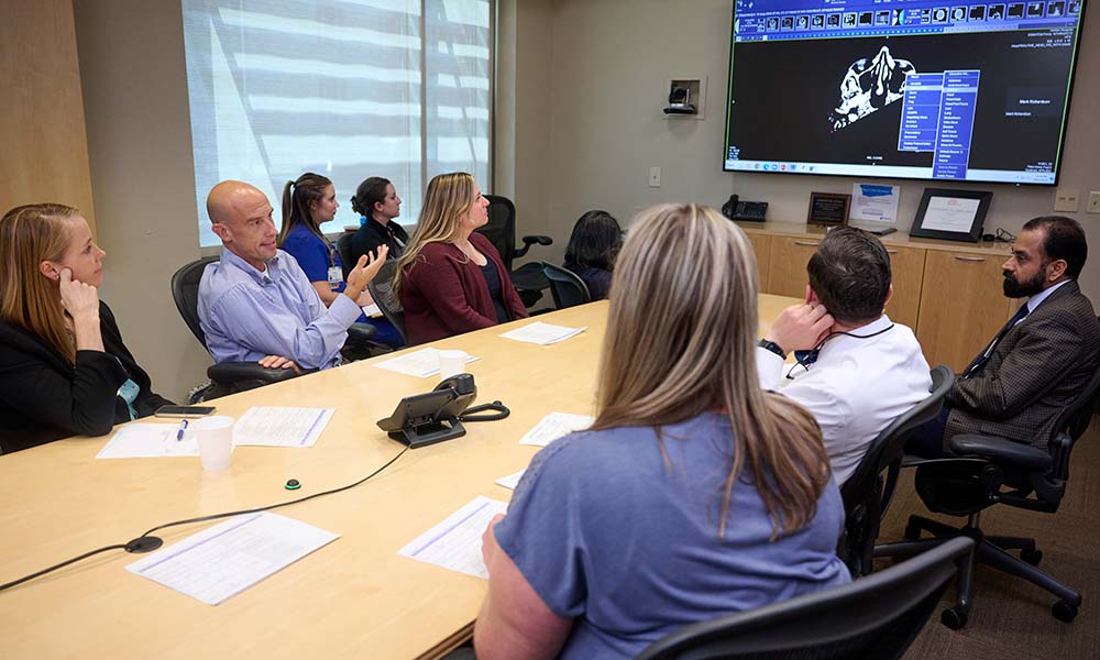 Head and neck tumor physicians review a case, offering their specialized viewpoints