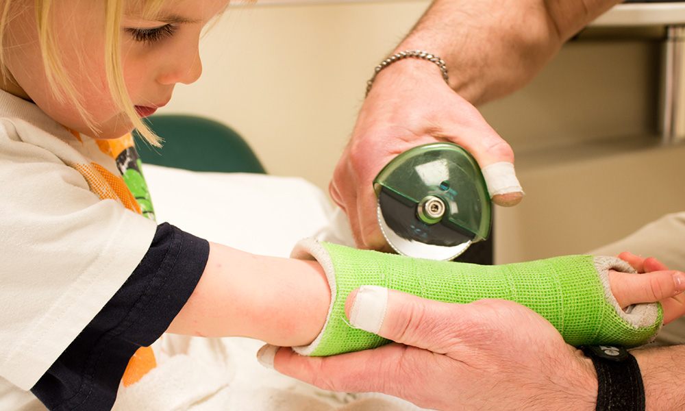 A medical provider is shown removing a child’s cast, illustrating multiple fractures in children
