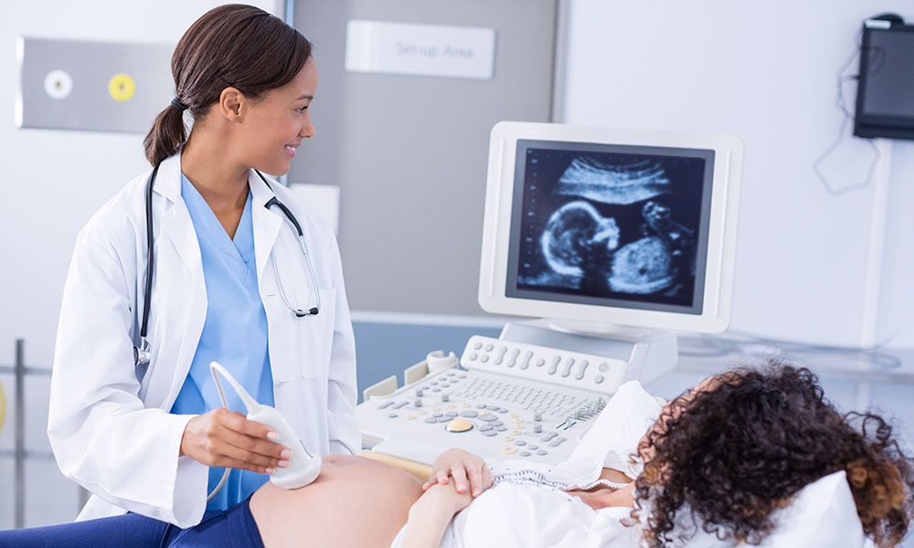 A provider is pictured conducting an ultrasound on a pregnant patient who may desire a second opinion.